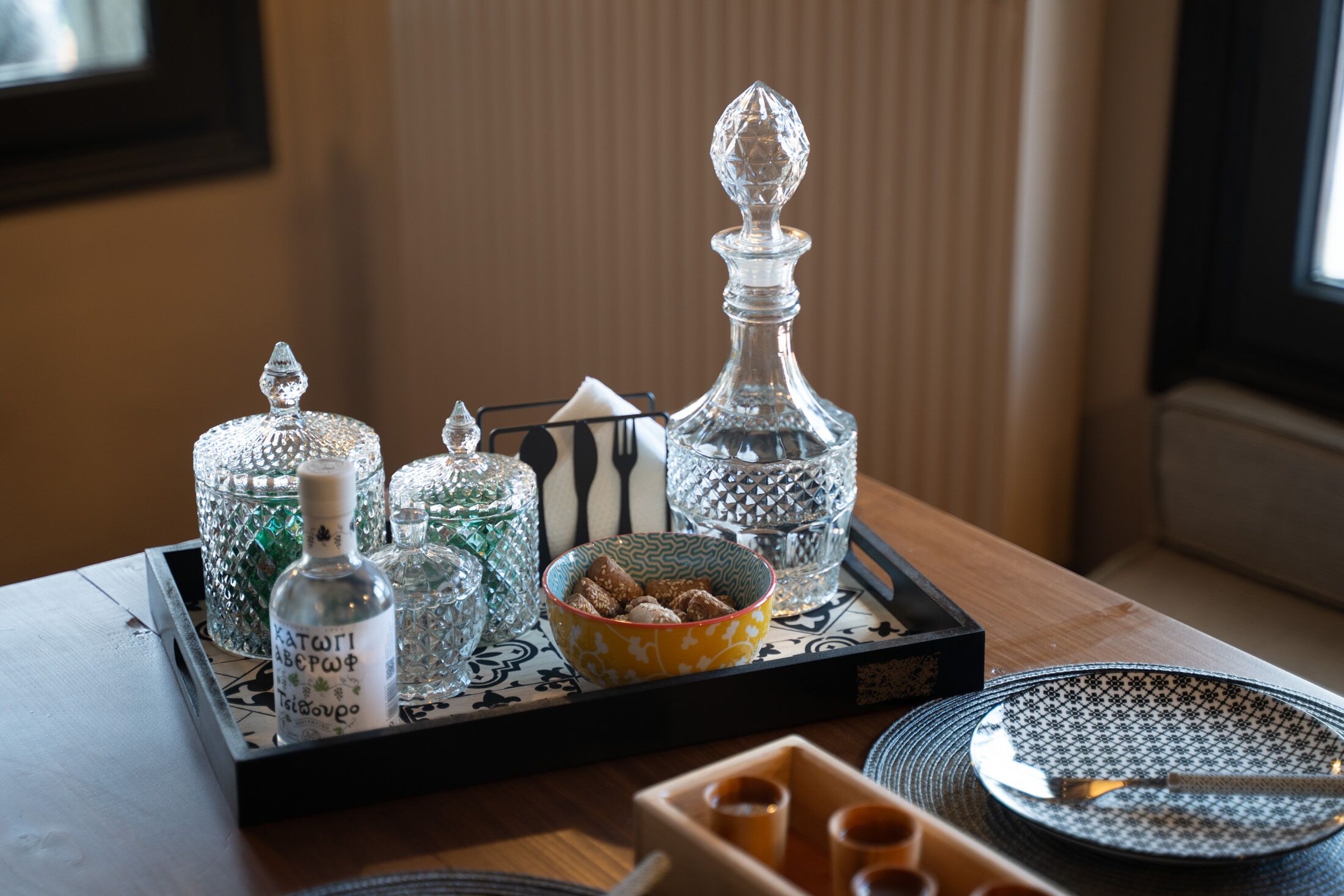 A tray with glass containers, a bowl with cookies, and a plate with a knife.