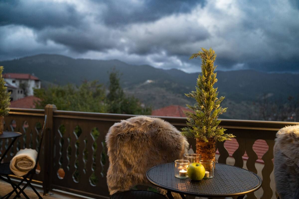 A balcony with a table, a potted plant, and a candle.