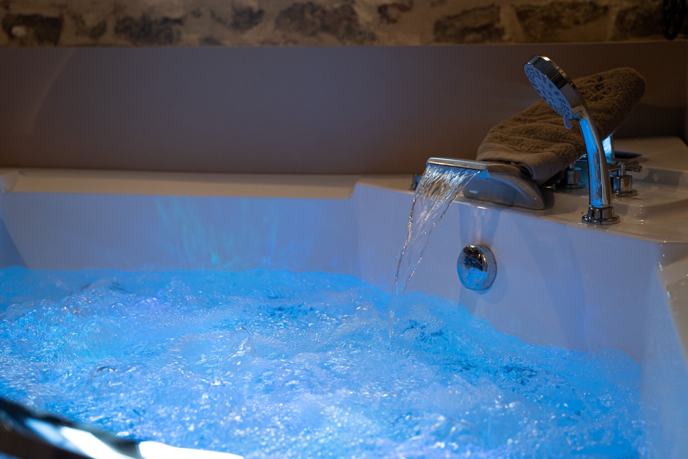 Eine Badewanne mit fließendem Wasser, ein Handtuch und eine Duschbrause.