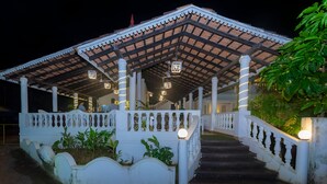 A covered outdoor area with a staircase leading up to a building. - Lillywoods NV beach Resort (Calangute)