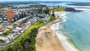 An aerial view of a coastal residential area with houses, a beach, and a bay. - Como - Absolute Beachfront with Uninterrupted Convent Beach Views - Holiday Yamba (Yamba)