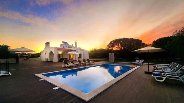 A swimming pool with lounge chairs, a patio area, and a building with a white facade. - Mourisca by Check-in Portugal (Vilamoura)