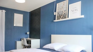 A bedroom with a bed, a desk, and a chair. There are two framed pictures on the wall. - Nice apartment in Pontoise with WiFi (Pontoise)