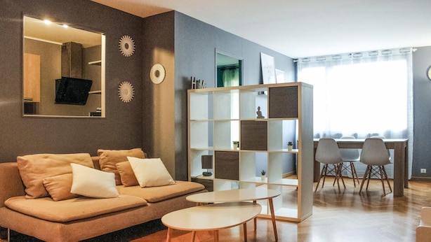 A modern living room with a sofa, coffee table, and a bookshelf. - Nice apartment in Pontoise with WiFi (Pontoise)