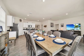 A modern kitchen with white cabinets, a refrigerator, and a microwave.