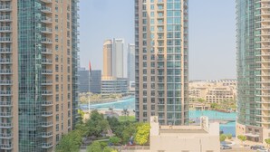 High-rise residential buildings with balconies, a swimming pool, and surrounding greenery. - Bella Vista - 29 Boulevard Downtown - 2BR - Partial Fountain View (Dubai)