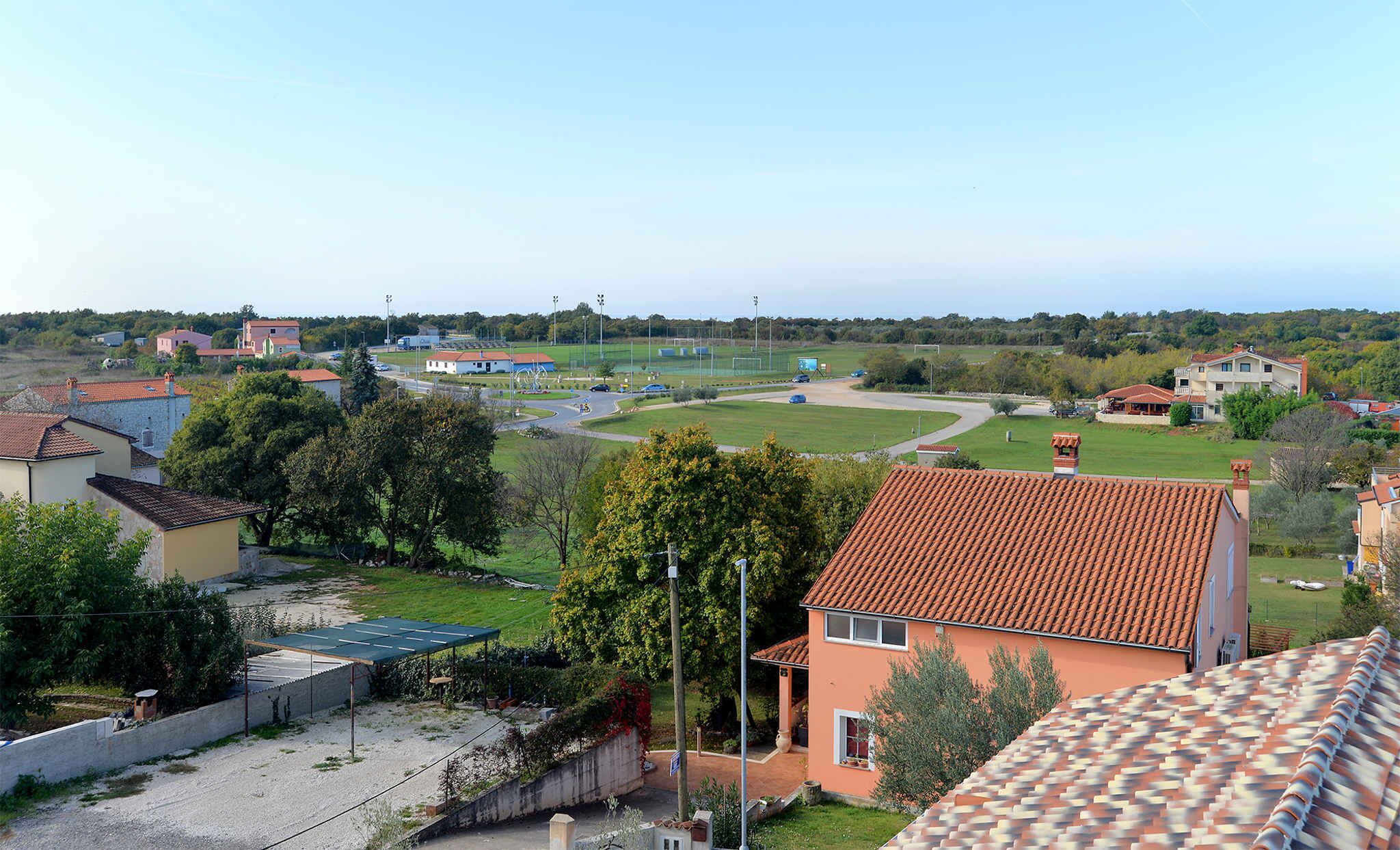 Zona residencial con casas, un campo deportivo y un estacionamiento.
