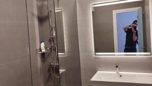 A modern bathroom with a glass-enclosed shower, a large mirror, and a white vanity. - Synathens II - Apartments & Studios (Athens)