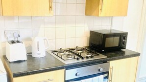 Eine Küche mit Gasherd, Mikrowelle, Toaster und Wasserkocher.