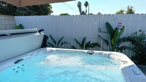 A hot tub with a white fence and plants in the background. - No Tax! Modern 4BR Pool Villa, Hot Tub, Arcade (Anaheim)