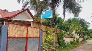 Ländliche Umgebung mit einem Schild für El Taraw Bed and Breakfast, einem eingezäunten Bereich und einer unbefestigten Straße.
