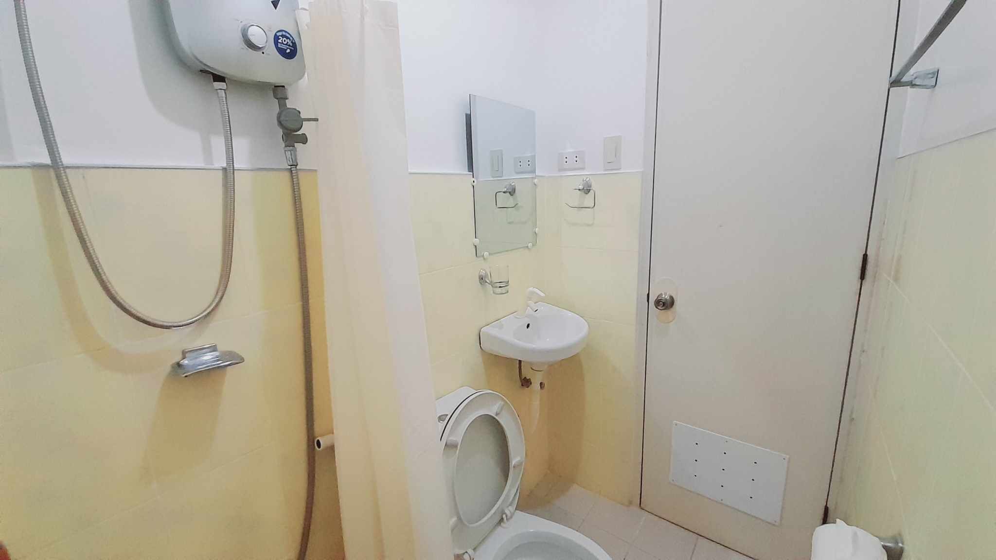 Um banheiro pequeno com vaso sanitário, pia e chuveiro.