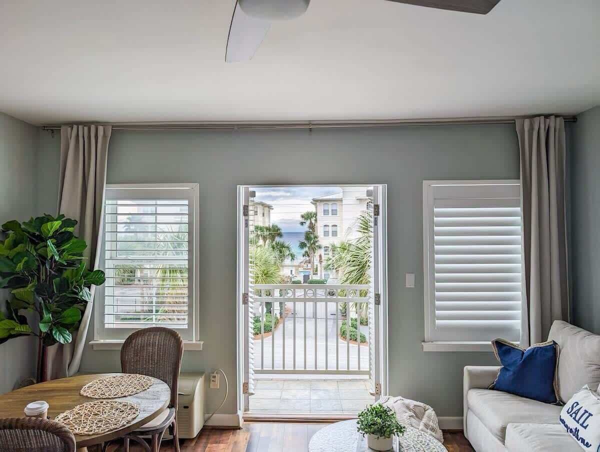 A living room with a balcony, a dining area, and a sofa.
