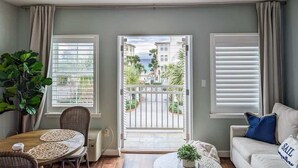 A living room with a balcony, a dining area, and a sofa. - AviaVista | Gulf Views, Steps to Private Beach (Santa Rosa Beach)