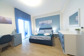 A modern bedroom with a bed, desk, and dresser. - Slow Chic Apartment b&b policlinico (Messina)