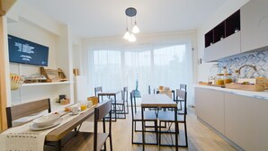 A modern kitchen with wooden countertops, a built-in oven, and a dining area with a long table and chairs. - Slow Chic Apartment b&b policlinico (Messina)