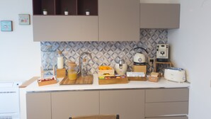 A kitchen with a white countertop, a sink, a toaster, and a cabinet with a geometric backsplash. - Slow Chic Apartment b&b policlinico (Messina)