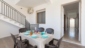 A dining area with a table set for four, chairs, a staircase, and a hallway. - 3311 Bianca House by Barbarhouse (Squinzano)