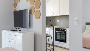 Une cuisine moderne avec des armoires blanches, un four noir et un plan de travail en bois.
