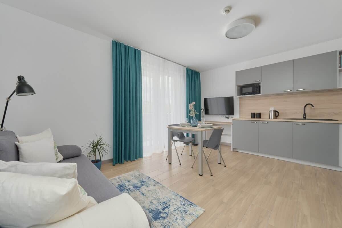 A modern apartment with a living room, dining area, and kitchen.