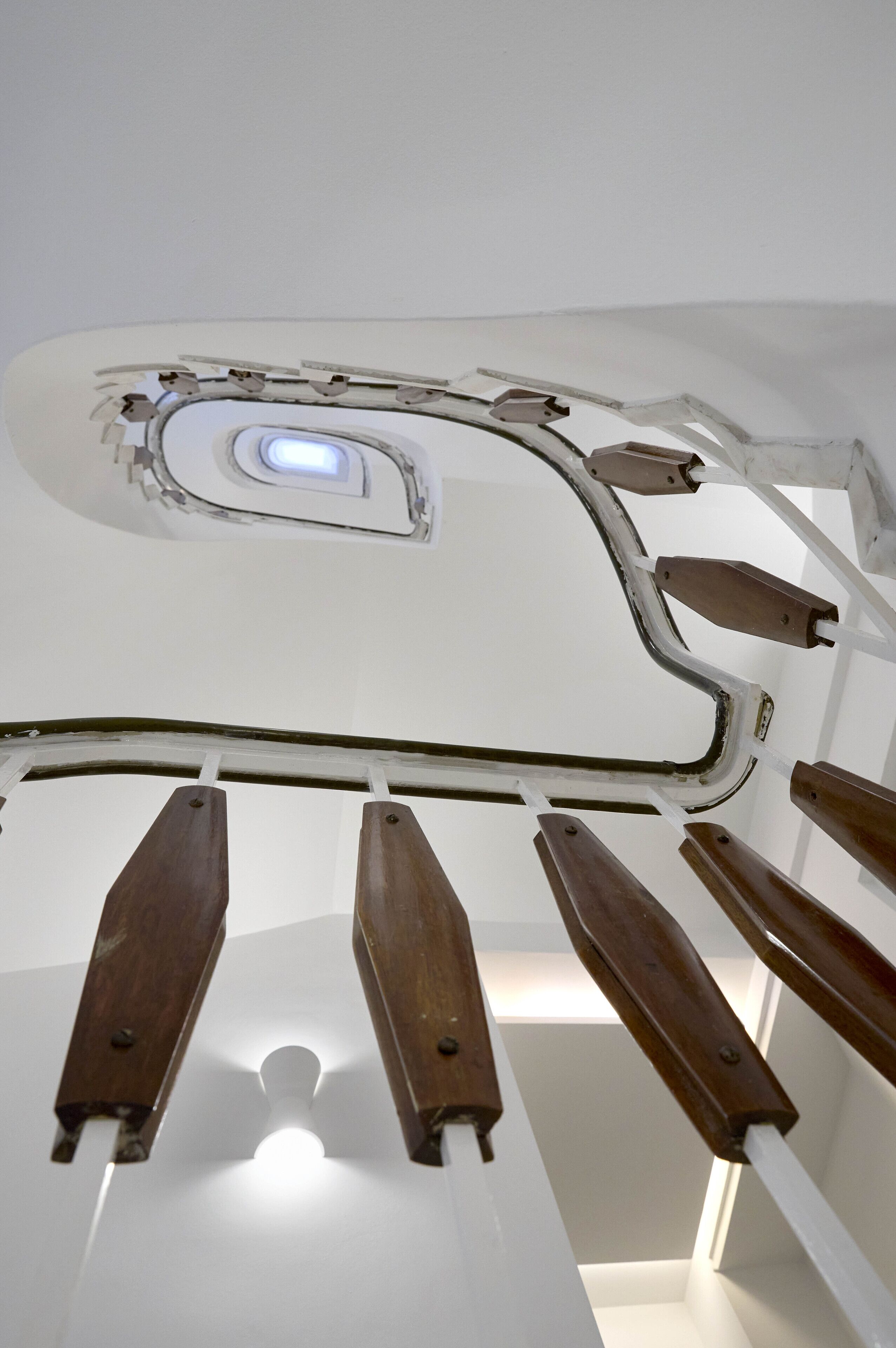 A ceiling with a skylight and wooden handrails.