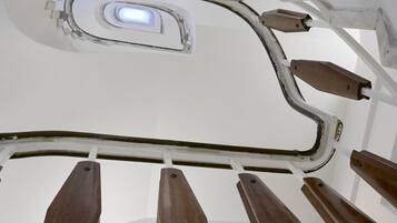 A ceiling with a skylight and wooden handrails.