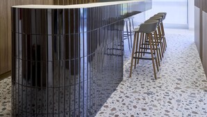 A modern bar area with a curved counter, bar stools, and a unique ceiling design. - Twinn Downtown Piraeus (Piraeus)