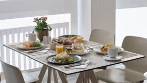 A breakfast table with plates of food, a coffee cup, and a fruit bowl. - Twinn Downtown Piraeus (Piraeus)