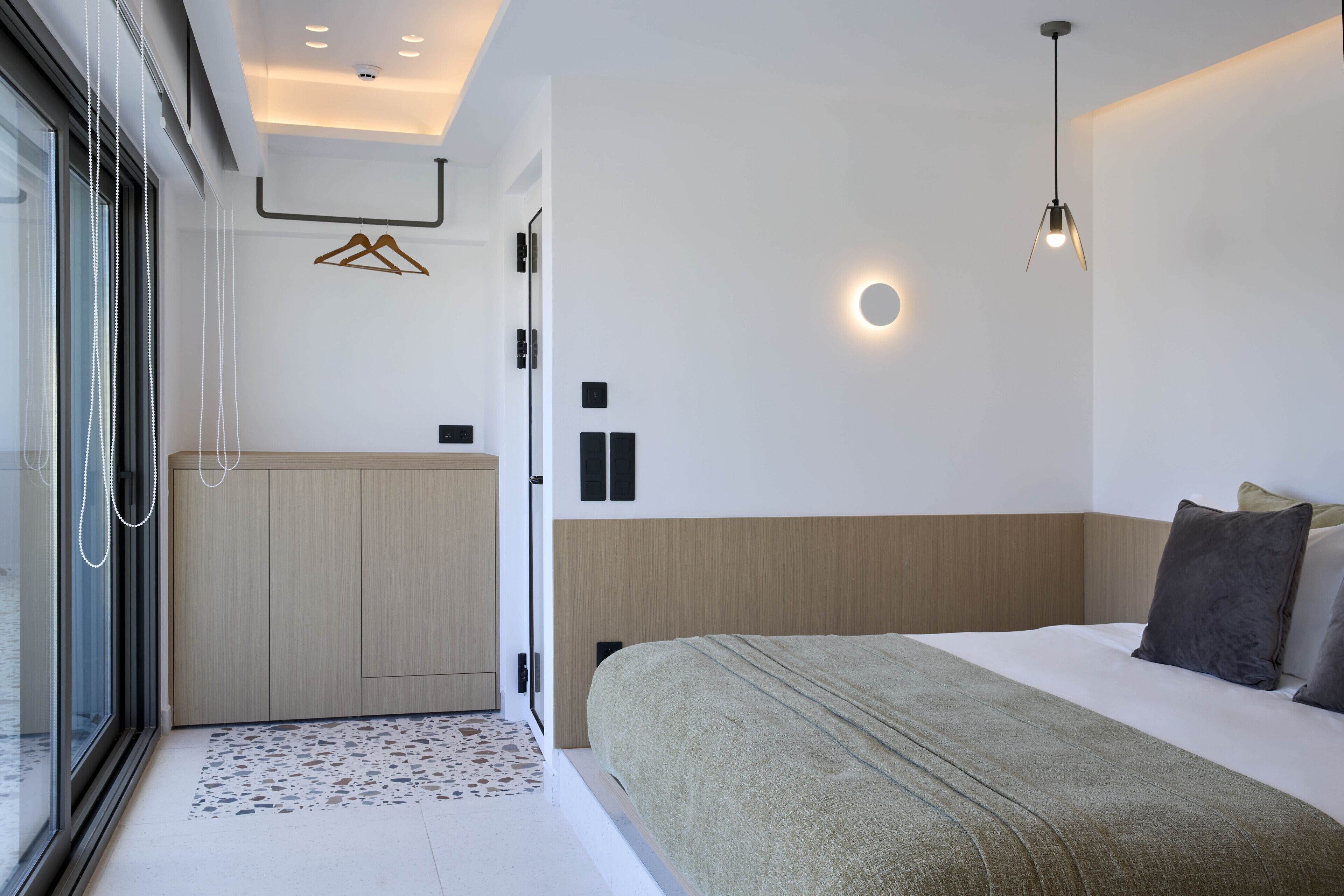 Een moderne slaapkamer met een groot bed, een inloopkast en een badkamer met een douchecabine van glas.