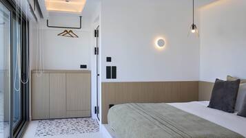 Een moderne slaapkamer met een groot bed, een inloopkast en een badkamer met een douchecabine van glas.