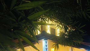 En veloplyst gårdsplads med plantekasser og en traditionel bygningsfacade.