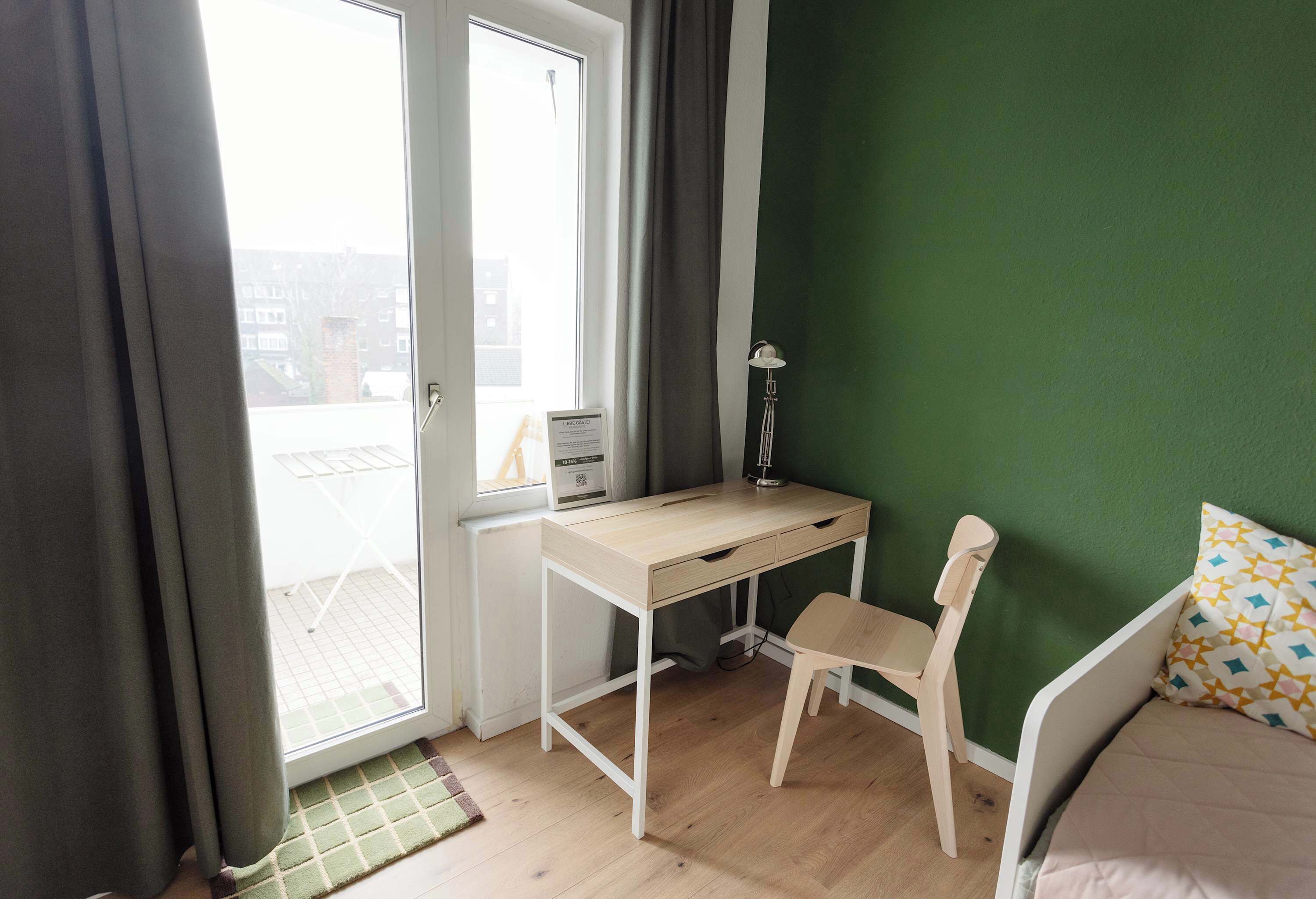 A room with a desk, chair, and bed.