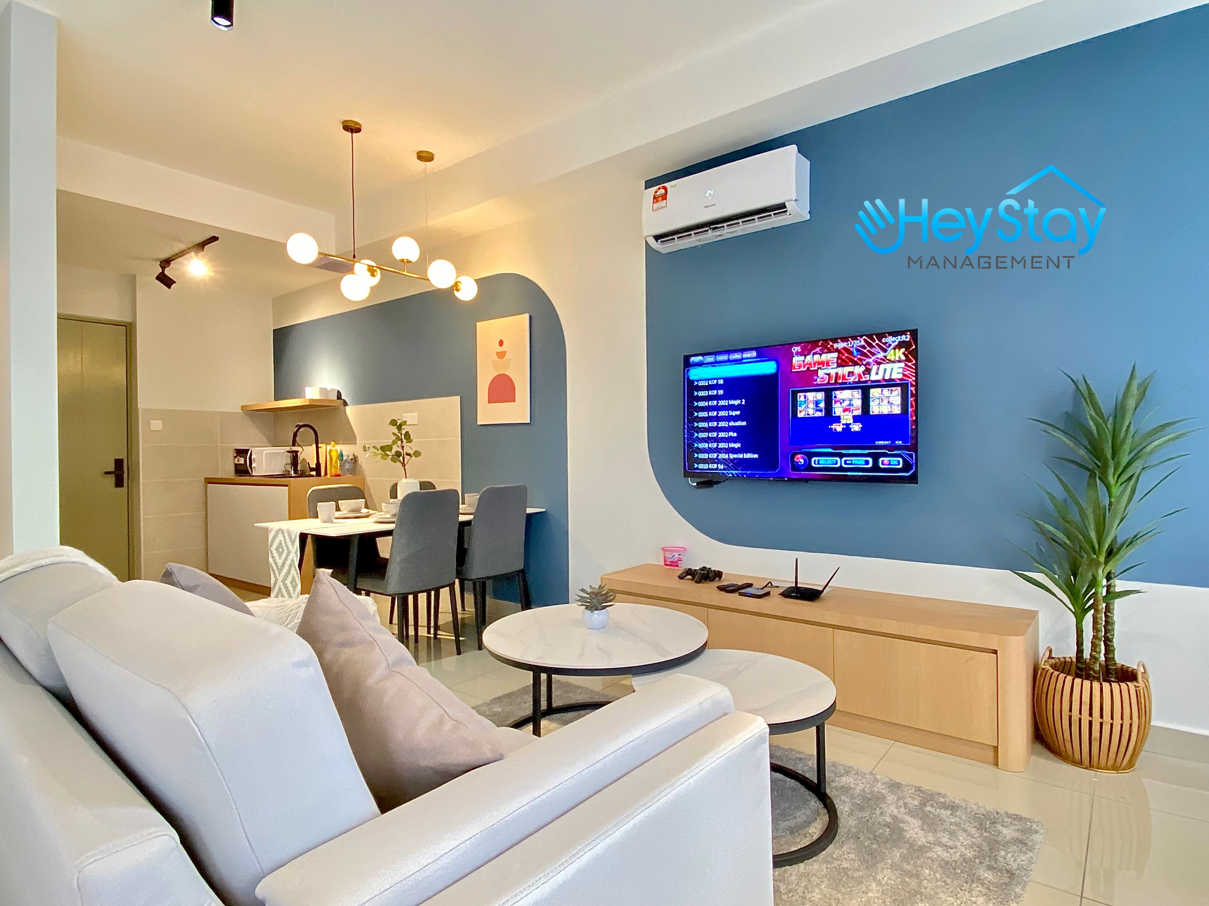 A modern living room with a sofa, a coffee table, and a TV mounted on the wall.