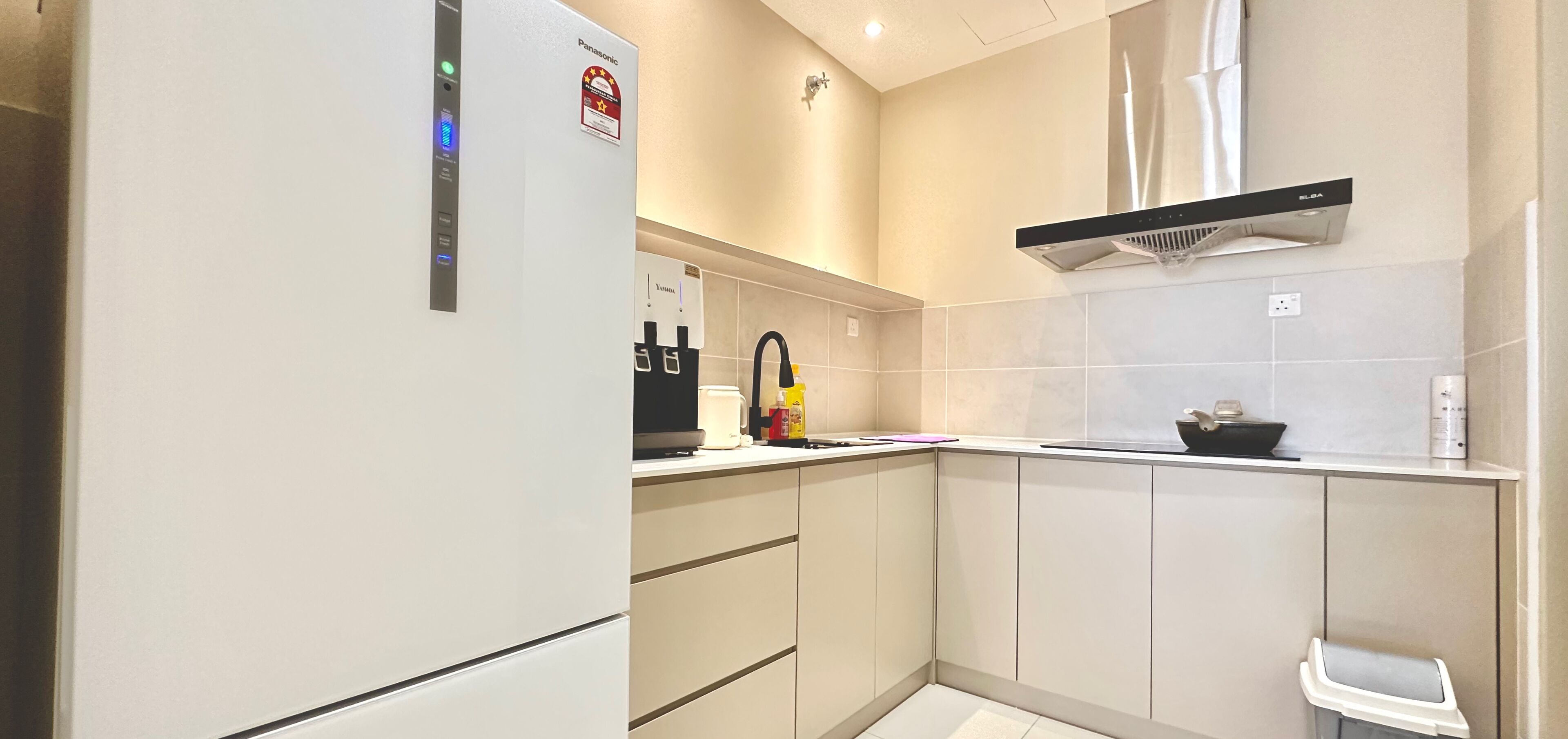 A modern kitchen with a built-in refrigerator, a coffee maker, and a microwave.