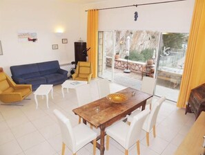 Relax in this inviting living space with a sofa, armchair, and dining table.