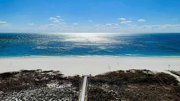 Une plage offrant une vue dégagée sur l’océan et un sentier menant à l’eau.
