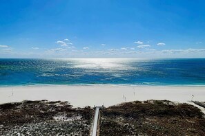 A beach with a clear view of the ocean and a pathway leading to the water.