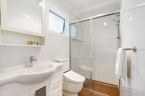 A modern bathroom with a glass shower enclosure, a white sink, and a toilet. - Bright & Lovely @ Balwyn Townhouse w/ parking, BBQ (Balwyn)