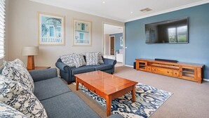 A living room with a sofa, coffee table, and TV stand.