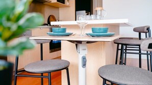Une cuisine moderne dotée d’un îlot central, de tabourets de bar et d’un plan de travail blanc.
