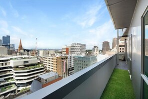 A high-rise building with a balcony overlooking a cityscape. - Panoramic View CBD 1 Bed Apt +OFFICE  (Collins) (Melbourne)