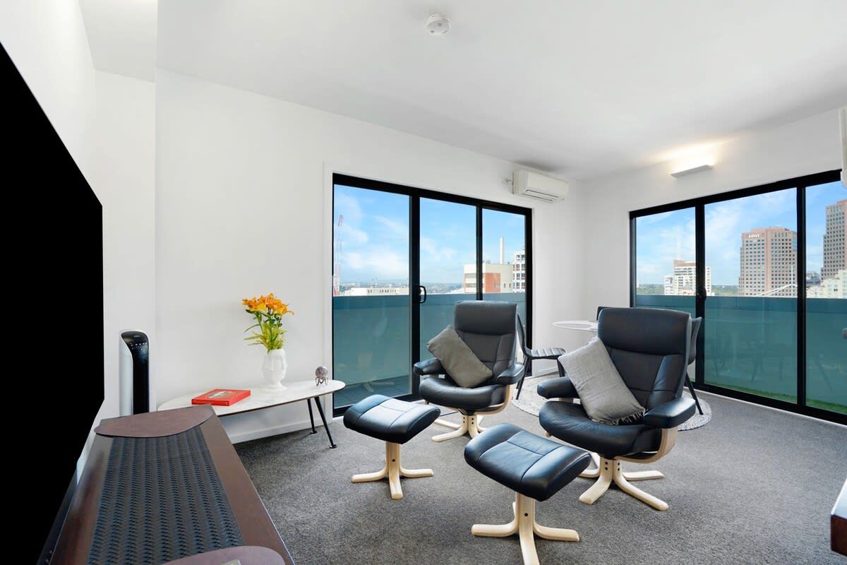 A modern lounge area with a view of the city skyline through large windows.