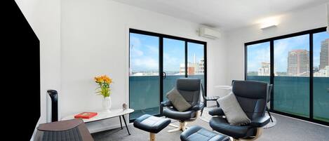 A modern lounge area with a view of the city skyline through large windows.