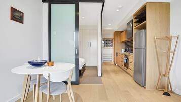 A modern kitchen with a built-in oven, a refrigerator, and wooden cabinets.
