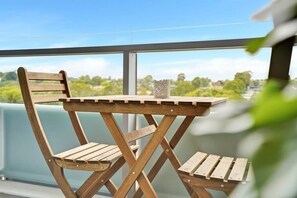 Een houten terras met een tafel en stoelen, met uitzicht op een mooi landschap.
