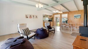 A modern living room with a fireplace, wooden flooring, and a dining area with natural light. - Rockpool House Short stroll to  St. Andrews Beach (Saint Andrews Beach)