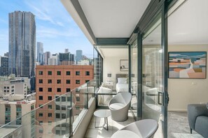 A modern balcony with a city view, furnished with white chairs and a small table. - Spacious&Cozy 2 bedroom City Point Melbourne Apt (Melbourne)