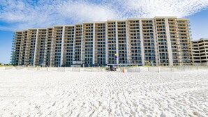 A multi-story hotel with numerous balconies, situated on a sandy beach. - 1BR Beachfront Beauty! (Orange Beach)