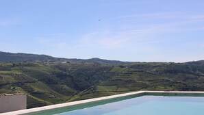 Une piscine offrant une vue sur des champs en terrasses et un ciel dégagé.