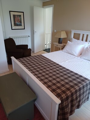 A bedroom with a bed, a chair, a bedside table with a lamp, and a framed picture on the wall. - No Coração do Douro, Entre o Pinhão e Favaios, um Espaço de paz e Serenidade (Favaios)
